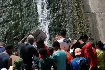 Caraqueños recogen agua en río contaminado debido a escasez por apagón - Internacionales - ABC Color