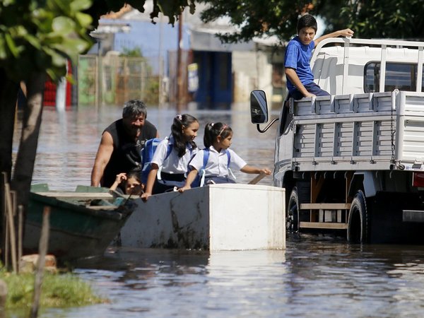 Usando una heladera como bote, lleva a sus nietas para que no pierdan clases