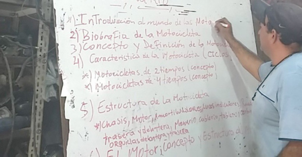Enseña Derecho en su taller de motos