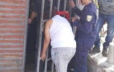 Por chismosa, su cabeza se atoró entre las rejas