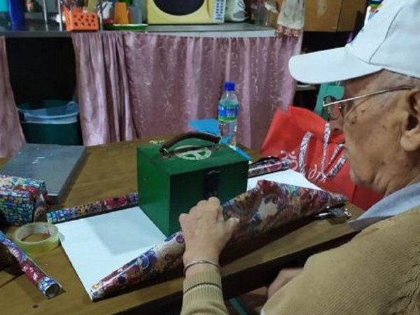 Fotografía de un abuelo envolviendo alcancía enternece en las redes