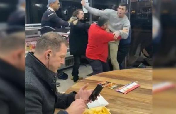 La pasiva reacción de un hombre mientras un grupo de personas se pelea a los puños - SNT