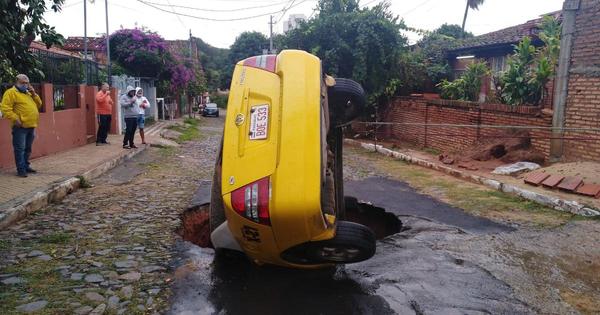 Taxi casi fue tragado por un enorme bache en barrio San Vicente
