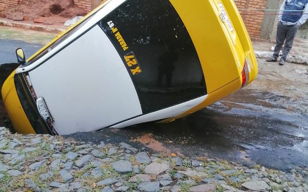 Asfalto se desmorona y taxi cae a pozo