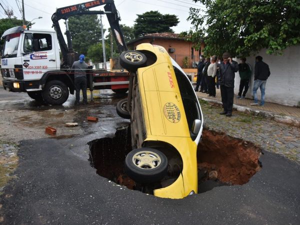 Susto en la calle: Taxi cae a un profundo bache