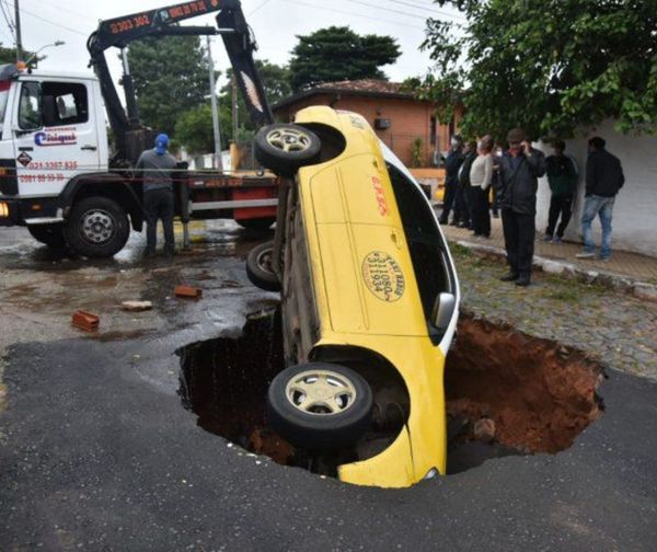 Taxi cae en enorme bache en Asunción
