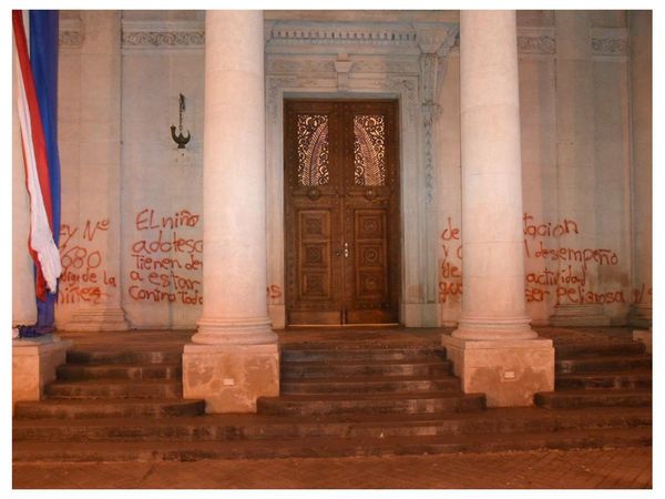 En protesta por muerte de niñas, queman bandera y pintan muro del Panteón de los Héroes