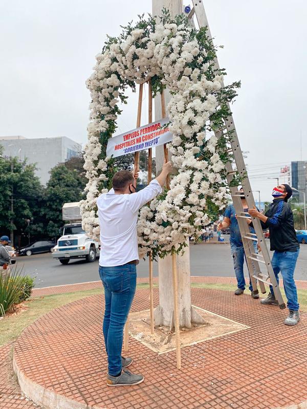 Corona de flores en mástil por empleos perdidos y por la inacción del Gobierno