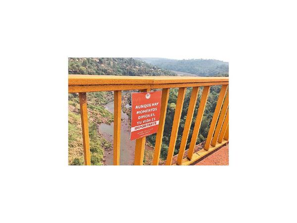 Jóvenes colocan carteles en puente para ofrecer ayuda