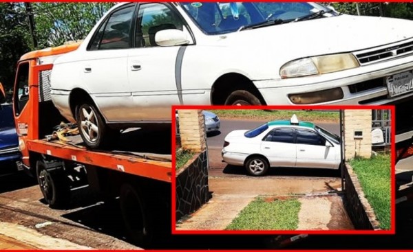 Con grúa retiran taxi estacionado frente al portón de una vivienda