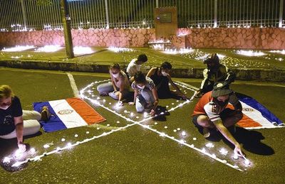 Familias encienden velas en memoria de fallecidos frente a sede de Salud - Nacionales - ABC Color
