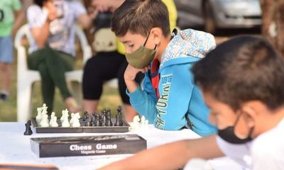 Chicos practican ajedrez al aire libre en Santa Rita