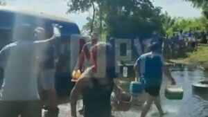Vecinos llevan combustible de camión transportador que volcó 