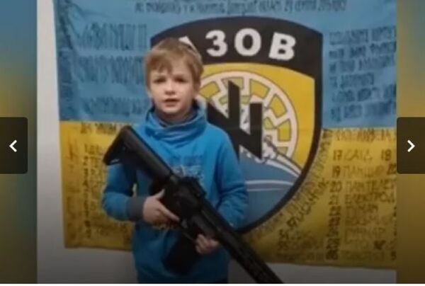 Un niño con un fusil posa frente a un símbolo nazi en un video propagandístico ucraniano