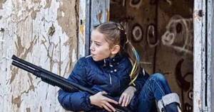 La Nación / Foto de la niña del rifle y el chupetín que dio la vuelta al mundo a través de las redes sociales