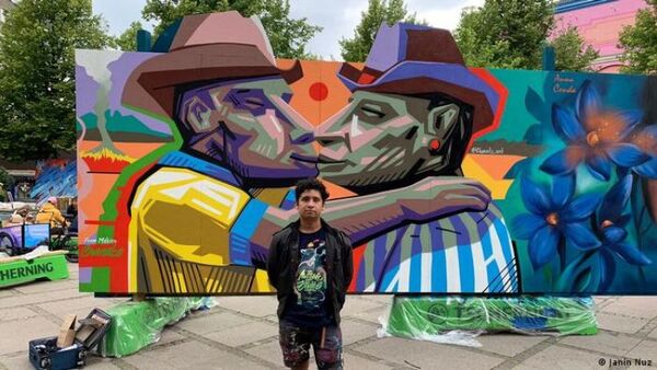 Artista mexicano pinta en Dinamarca mural de beso entre hombres hinchas de clubes de fútbol rivales
