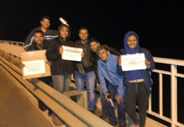 Jóvenes llevan la palabra de Dios en el puente