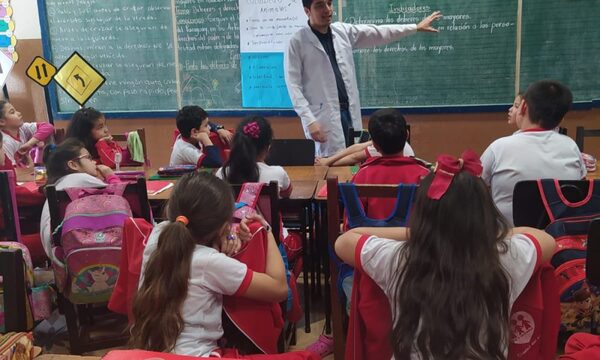 Estudiante de veterinaria orienta a niños sobre cuidados de mascotas.