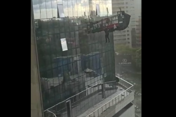 (VIDEO) ¡Impresionante! Trabajador no pudo bajar y quedó colgado en lo alto de un edificio