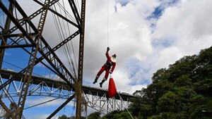 Papá Noel bombero baja puente de 75 m para dar regalos a niños guatemaltecos
