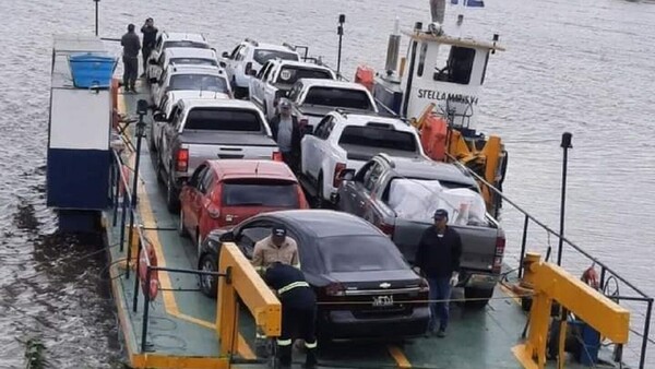 Larga fila vehículos para cruzar en balsa el río Paraguay rumbo a Pilar para pasar Semana Santa