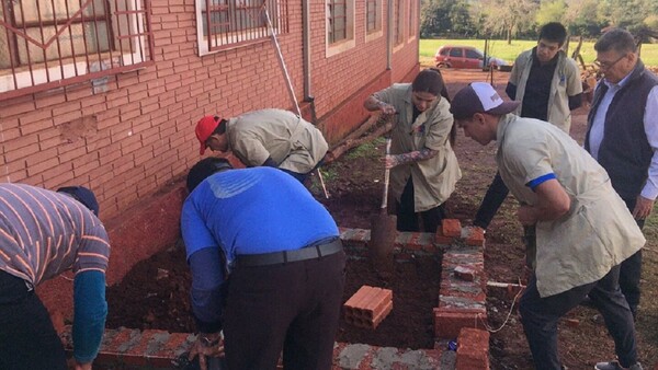 Alumnos de albañilería construyen sanitario en una escuela de Obligado