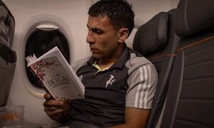 Junior Alonso lee un libro mientras vuela para enfrentar a River