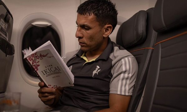 Junior Alonso lee un libro mientras vuela para enfrentar a River