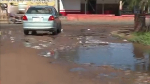 Grandes agujeros con agua en calle de la zona de Limpio - SNT