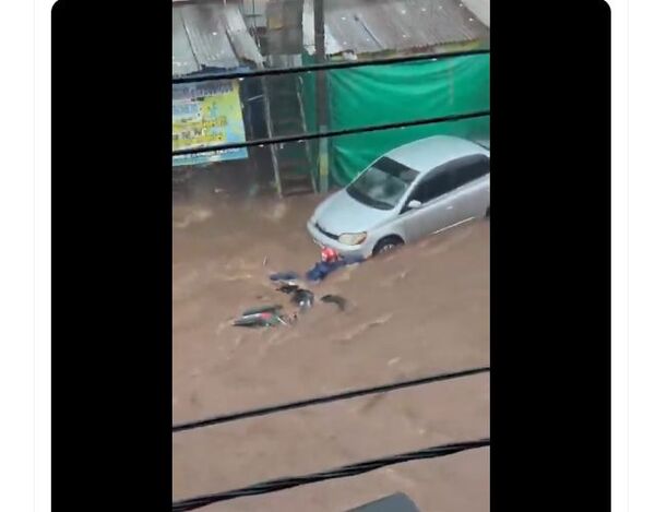 (VIDEO). Mujer es arrastrada con su motocicleta por el enorme raudal