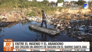 Así cruzan un arroyo de basura en el barrio Santa Ana
