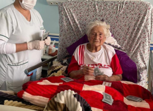 Enfermera acompaña con amor a abuela de 93 años y disputa partida de barajas