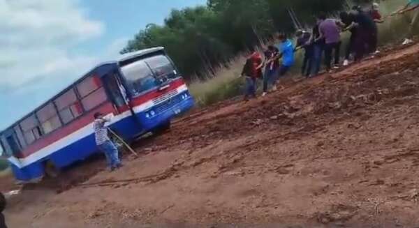 Pasajeros tiran de un colectivo atascado en el barro: el drama de los caminos en Moisés Bertoni, departamento de Caazapá - Nacionales - ABC Color