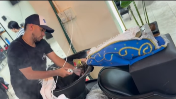 El peluquero que peina y coloca el cabello a las réplicas de la Virgencita