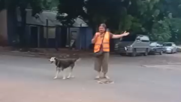 Con su perrita y un silbato, Ña Ramona ordena el tránsito frente a una escuela